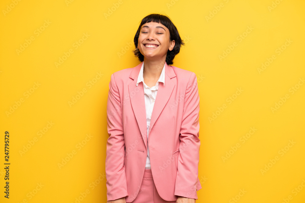 Modern woman with pink business suit smiling a lot while putting hands on chest Modern woman with pink business suit smiling a lot while putting hands on chest