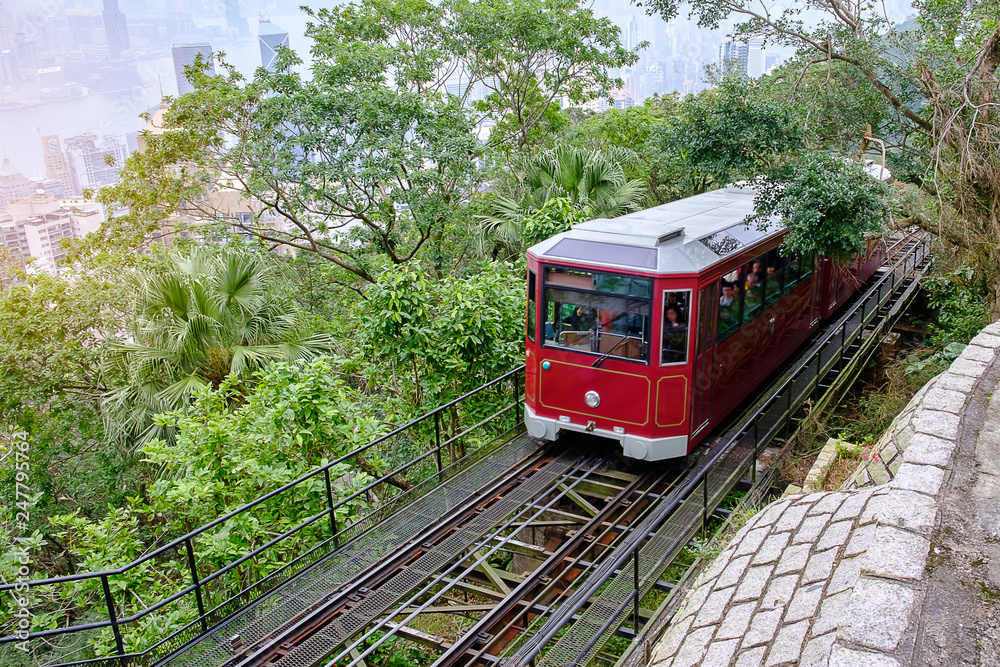 Naklejka premium Victoria Peak Tram and unidentified people with Hong Kong city skyline background. landmark and destination for tourist attractions in HK