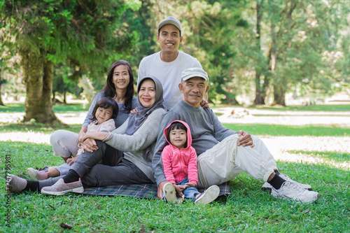 portrait of family with parent, grandparent and grandchildren together relaxing in the park © Odua Images