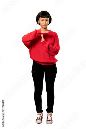 A full-length shot of a Short hair girl with red sweater making time out gesture over isolated white background