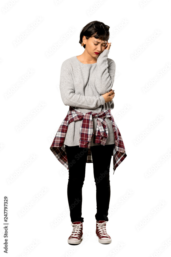 A full-length shot of a Young woman with short hair with headache over isolated white background A full-length shot of a Young woman with short hair with headache over isolated white background