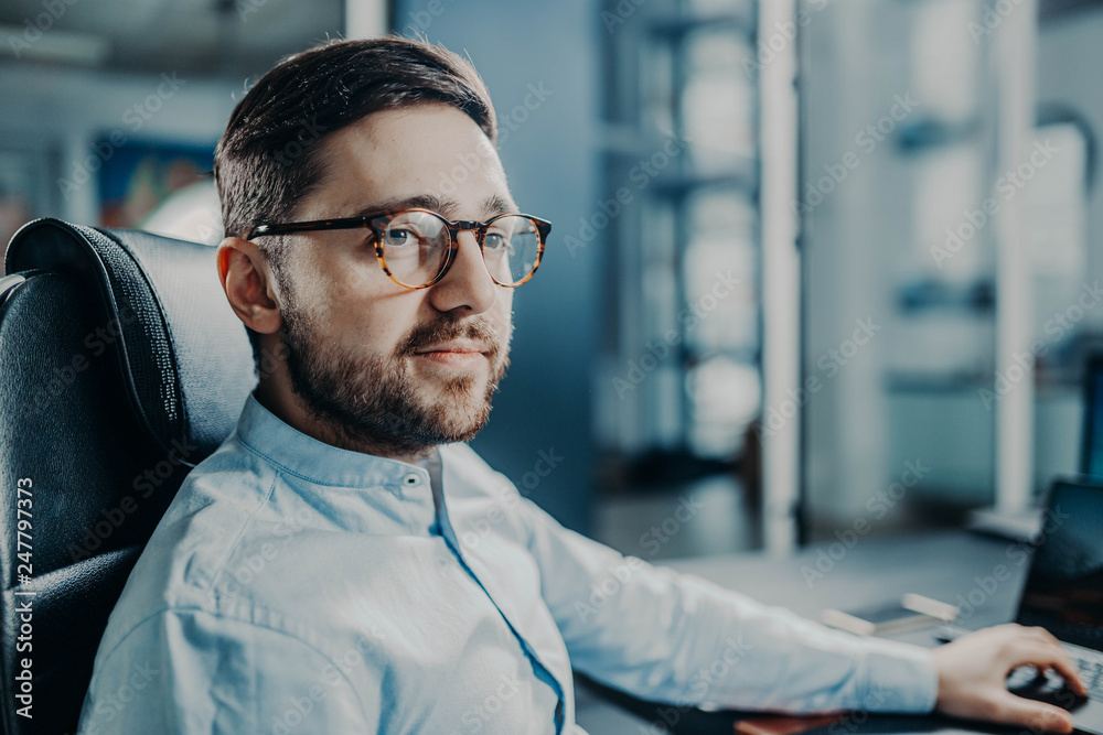 Obraz premium bearded trendy modern business man at work in office. manager with glasses.
