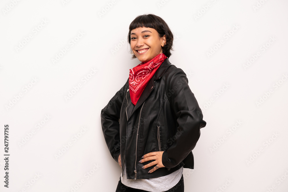 Woman with leather jacket and handkerchief posing with arms at hip and smiling Woman with leather jacket and handkerchief posing with arms at hip and smiling