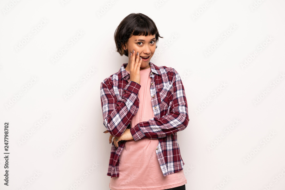 Young woman with short hair surprised and shocked while looking right Young woman with short hair surprised and shocked while looking right