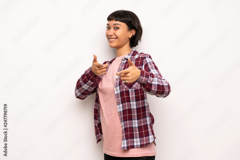 Young woman with short hair pointing to the front and smiling Young woman with short hair pointing to the front and smiling