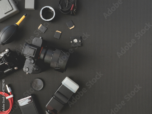 Fototapeta Naklejka Na Ścianę i Meble -  top view of work space photographer with digital camera, flash, cleaning kit, memory card, external harddisk, USB card reader, laptop and camera accessory on black table background.