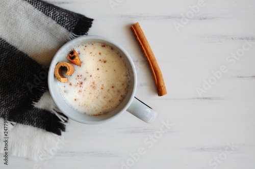 Turkish salep (milky traditional hot drink) with cinnamon for winter on wooden white table. photo