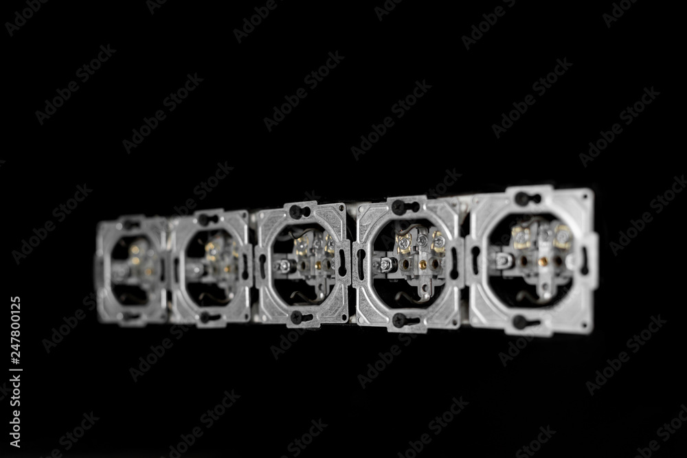 Five outlets in line, disassembled and mounted in black glass wall