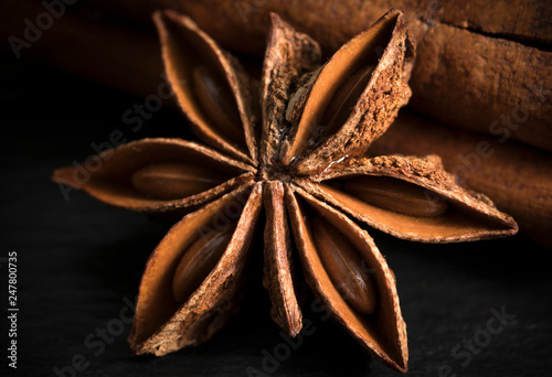 Star anise with cinnamon stick on a wooden table.