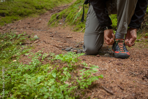 fastening your mountain shoes inside a forest