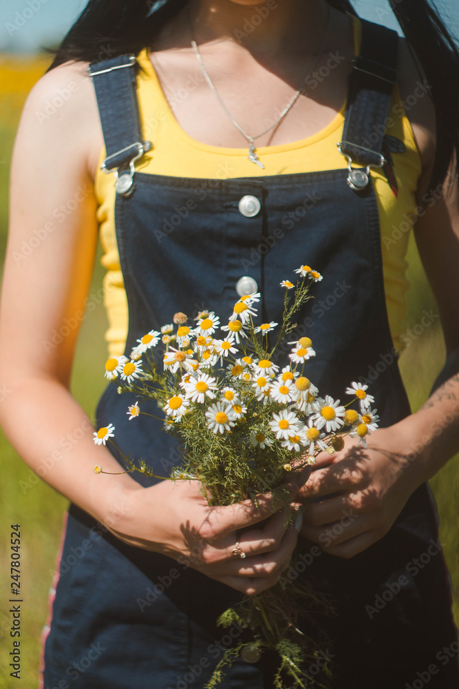 Girl holding a bouquet of chamomiles