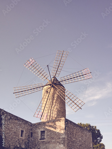 Retro toned picture of an old windmill at sunset, Mallorca, Spain.