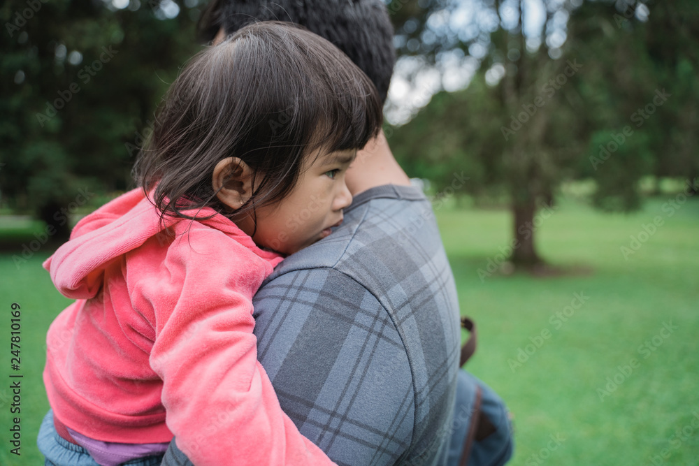 upset kid carried by daddy while in the park upset kid carried by daddy while in the park
