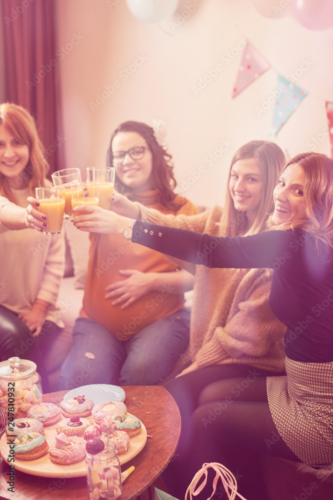 Pregnant woman celebrating baby shower party with friends.