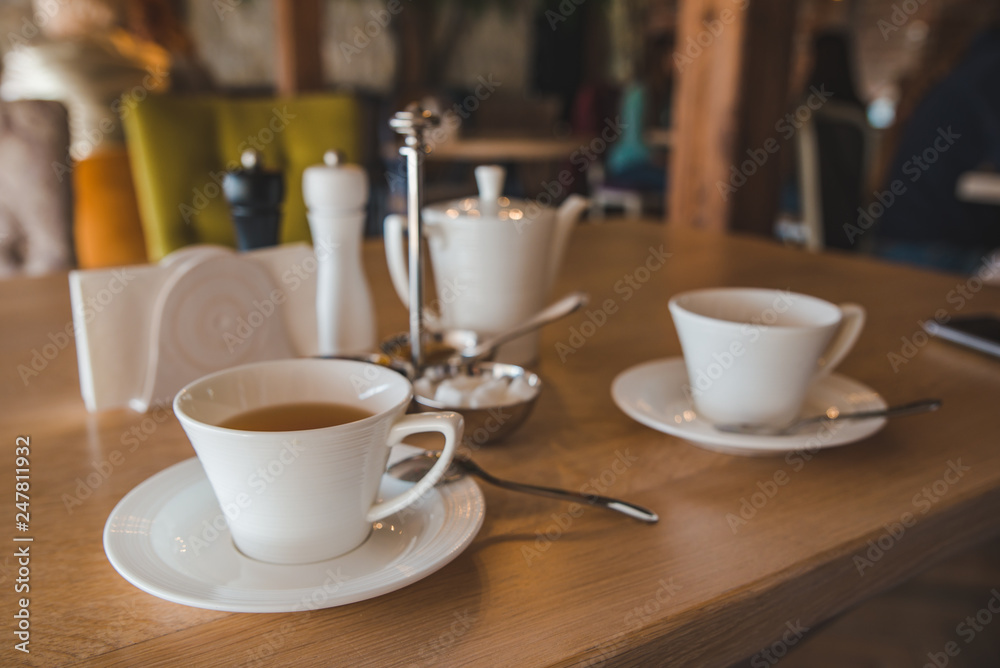 Fototapeta premium white cups with tea close up in cafe table