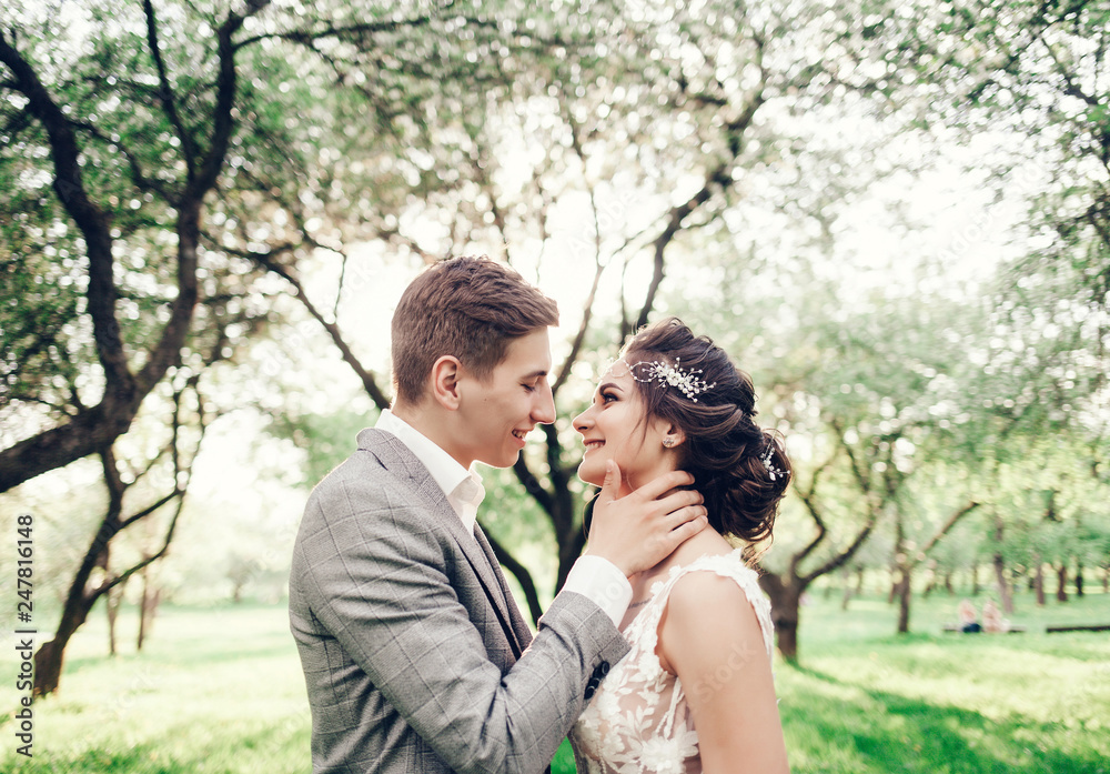 Amazing happy wedding couple. Pretty bride and stylish groom in spring park Amazing happy wedding couple. Pretty bride and stylish groom in spring park