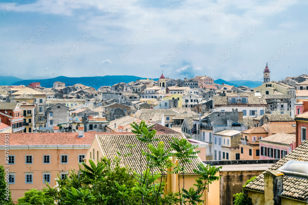 View on Corfu city or Kerkyra from New Fortress. Background with skyline of typical houses of old town. Tourist attraction and popular vacation destination. Sunny day in beginning of June. 