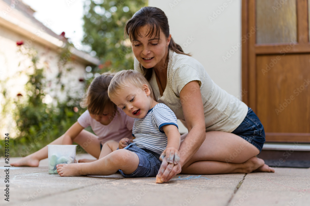 Mother with children drawing with chalk Mother with children drawing with chalk