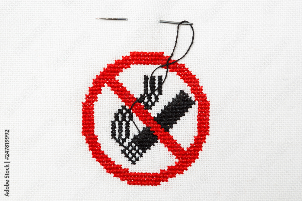 Sign of a stop of a cigarette embroidered on a white fabric. - obrazy, fototapety, plakaty 