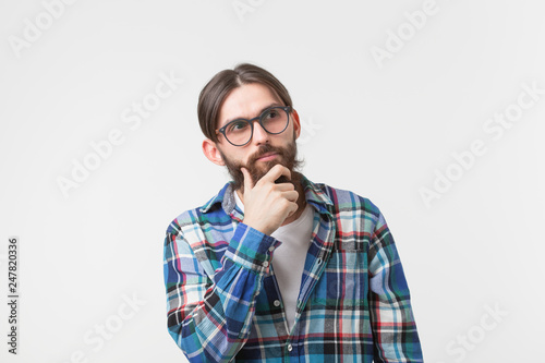 Emotions and people concept - Bearded hipster man thinking about something on white background. © satura_
