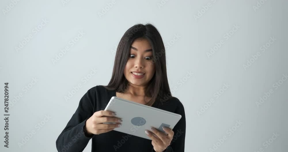 Beautiful asian woman playing game online on digital tablet Beautiful asian woman playing game online on digital tablet
