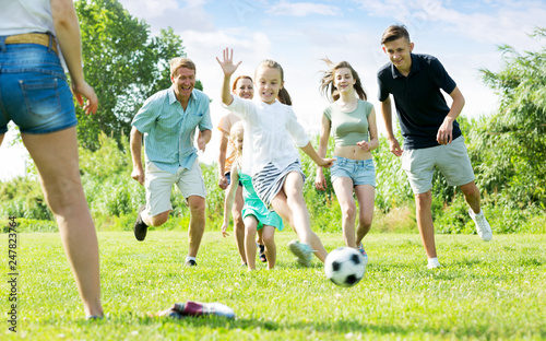 Parents with children playing football on outdoor