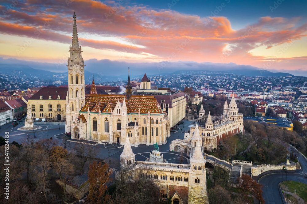 Budapest, Hungary - Aerial view of Matthias Church and Fisherman's Bastion (Halaszbastya) at sunrise with beautiful golden clouds at winter time