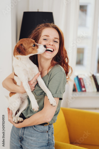 Laughing woman holding her pet dog