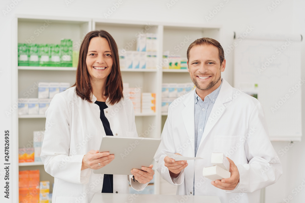 Two happy friendly pharmacists in a pharmacy Two happy friendly pharmacists in a pharmacy