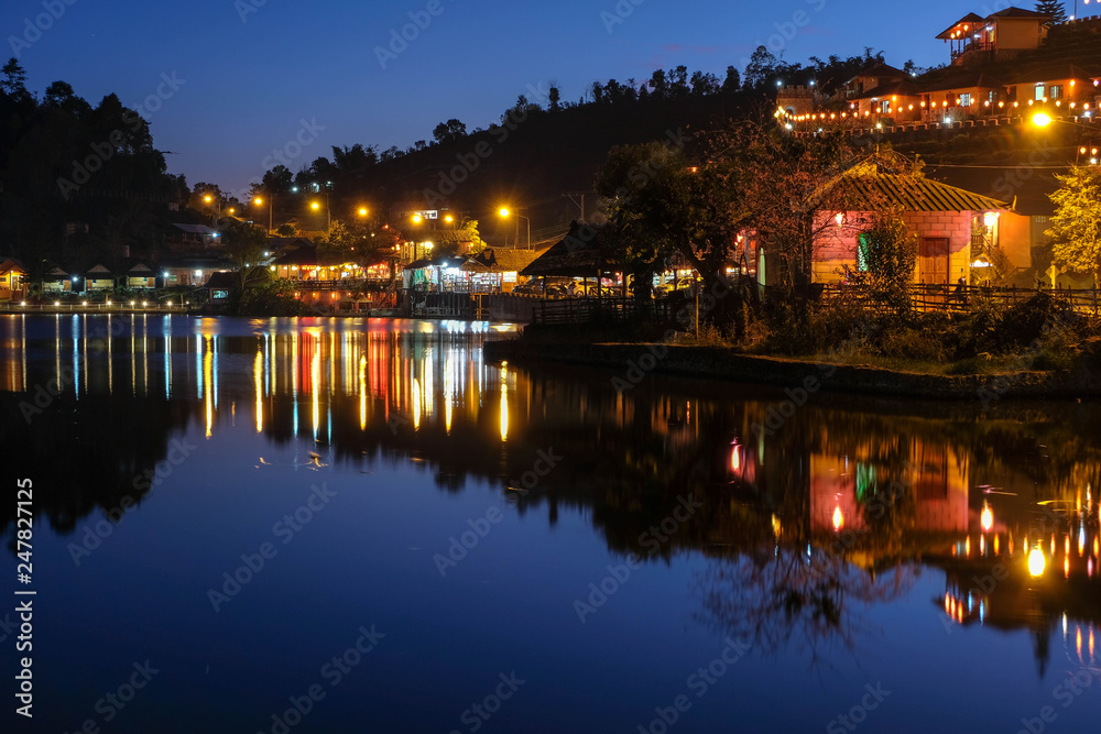 reflection lake with old house in night time at ban ruk thai Mae Hong Son