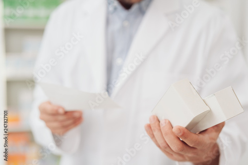 Pharmacist dispensing boxes of medication