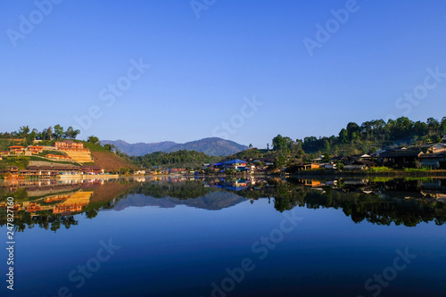 beautiful lake with reflection of water in morning time at ban rak thai chinease refugee village with chinease style building at Mae Hong Son Thailand