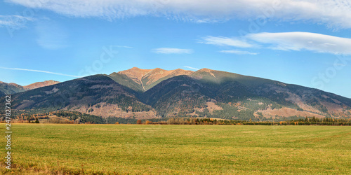 High resolution panorama of Western Tatras (Zapadne Tatry, Liptov region) with mount Baranec peak, green meadow in foreground, on clear autumn day. photo