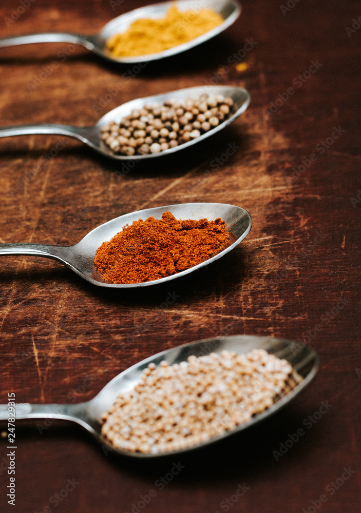 Colourful various herbs and spices for cooking on dark background.The herbs and spices on a wooden background. Colourful various herbs and spices for cooking on dark background.The herbs and spices on a wooden background.