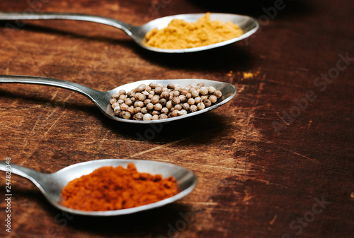 Colourful various herbs and spices for cooking on dark background.The herbs and spices on a wooden background.