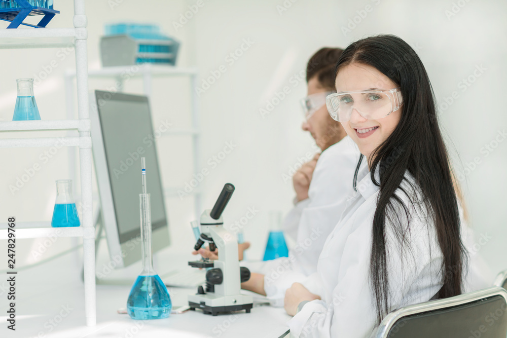 side view.female scientist sitting at a lab table side view.female scientist sitting at a lab table