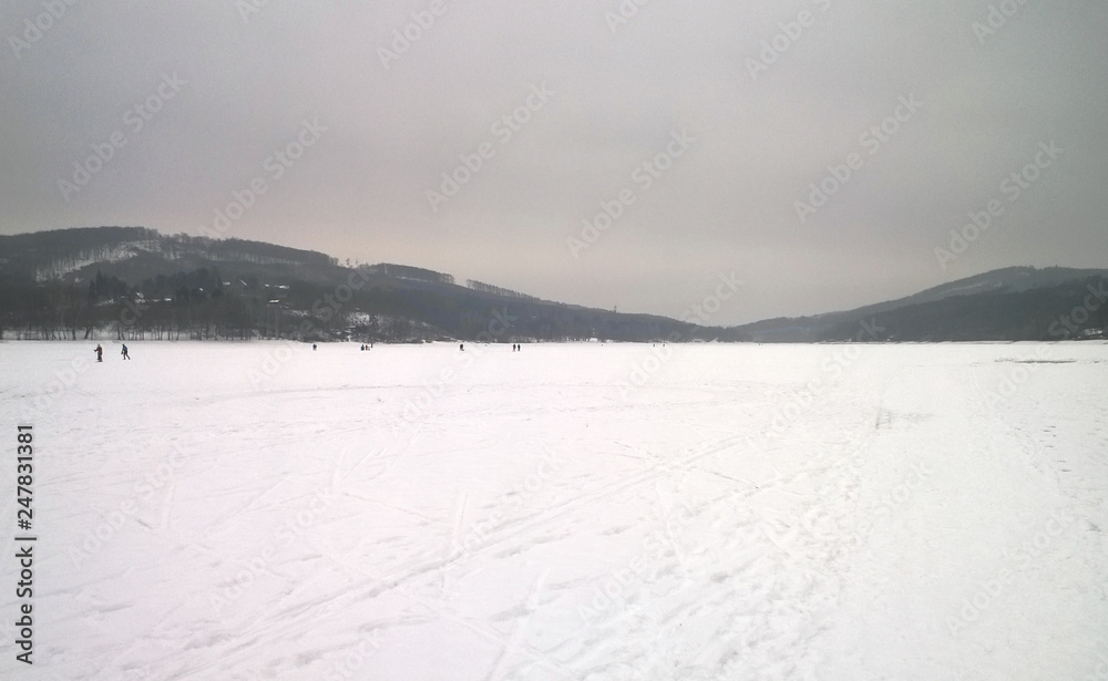 Photo of a large frozen lake covered in snow