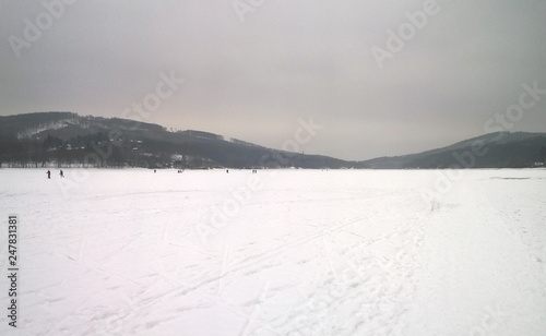 Fototapeta Naklejka Na Ścianę i Meble -  Photo of a large frozen lake covered in snow