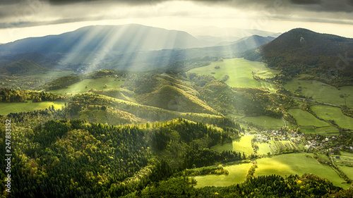 Landscape and nature in the spring. Landscape with dramatic sky and green meadows. The sun rays through the clouds.