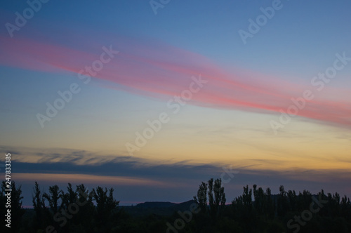 Landscape with dramatic light - beautiful golden sunset with saturated sky and clouds.