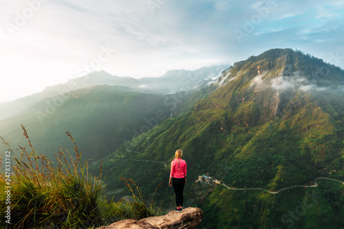 Girl meets sunrise in the mountains. Girl traveling to Sri Lanka. Mountain sports. Athlete happy finish. Mountain tourism. Walking tour. The journey to the mountains. Man on the edge of the mountain photo