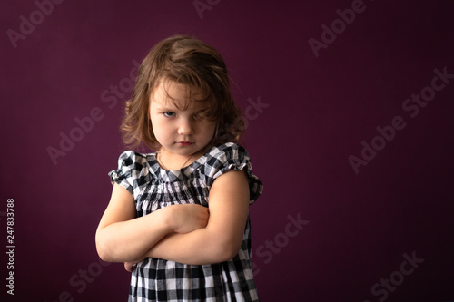 Angry sad girl child in dress dark background