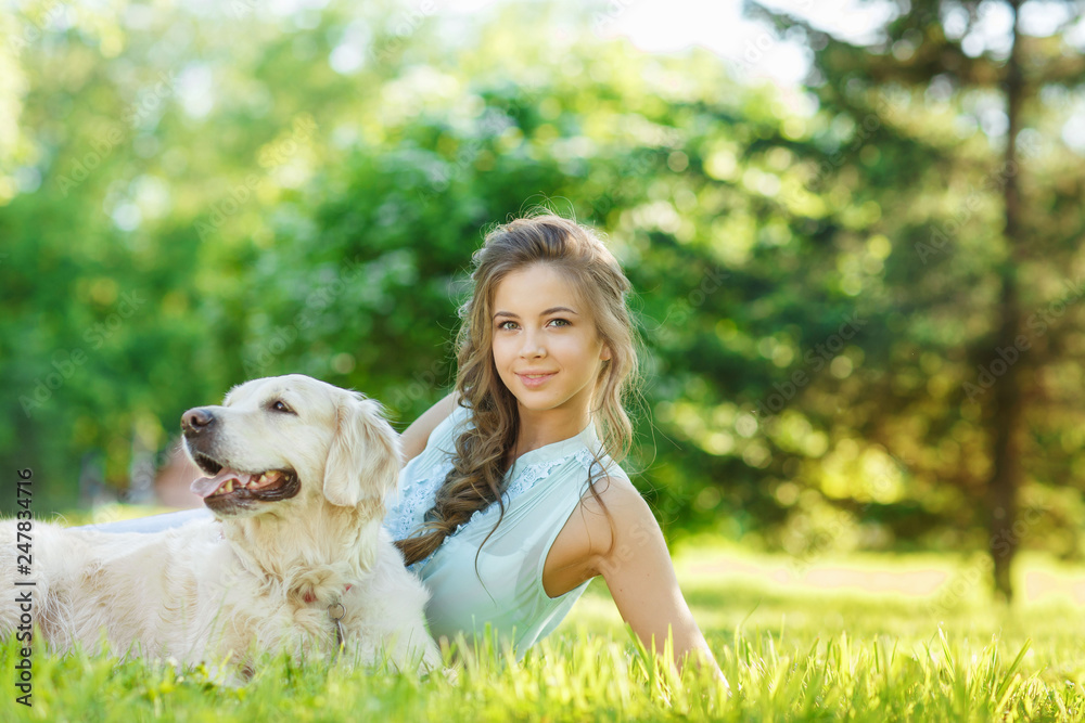 Young woman with golden retriever dog in the summer park Young woman with golden retriever dog in the summer park