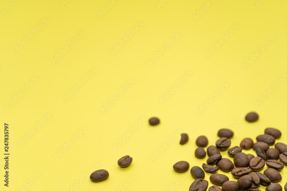 Some coffee beans are scattered on a yellow background. Some coffee beans are scattered on a yellow background.