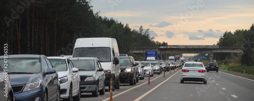 Traffic jam - a lot of cars on the highway on a summer day at rush hour, delay