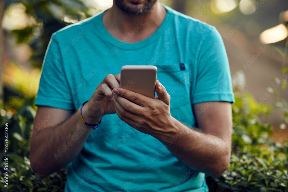 Fototapeta premium Modern man using cellphone outdoors.