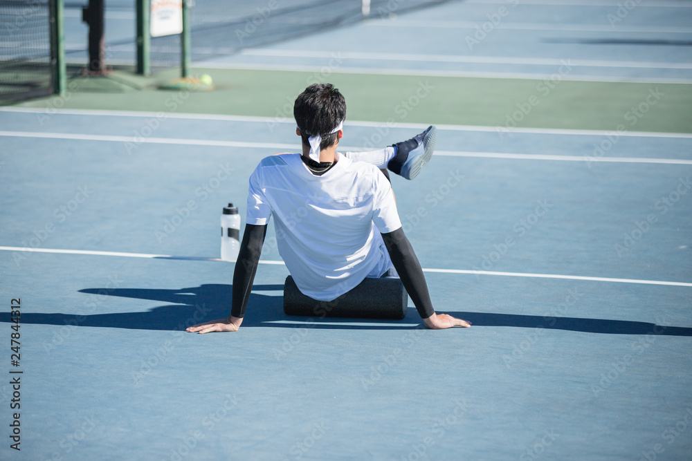 Young Tennis Player Using Foam Roller