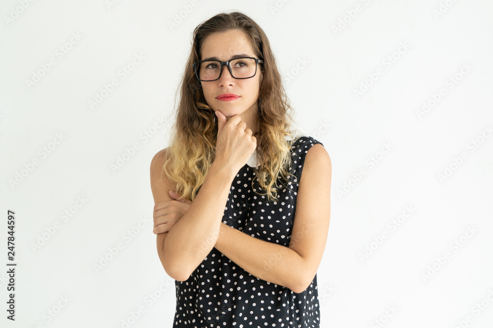 Dreamy pretty young woman touching chin and looking away Dreamy pretty young woman touching chin and looking away