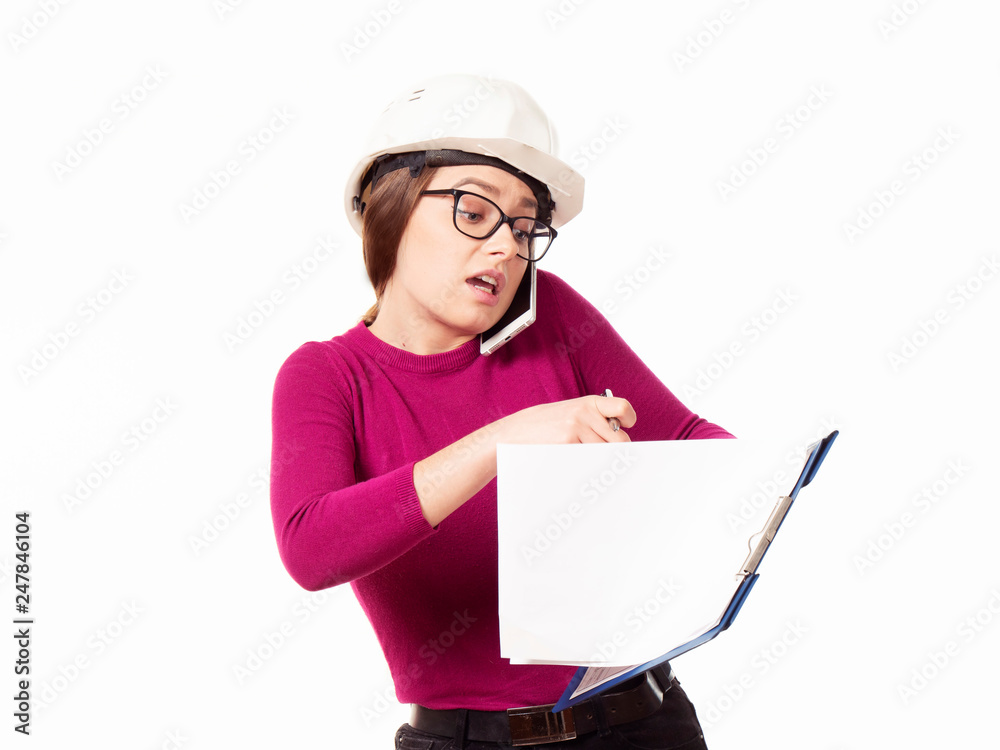 Emotional girl brigadier in a white helmet with glasses and a folder in his hands on a white background Emotional girl brigadier in a white helmet with glasses and a folder in his hands on a white background