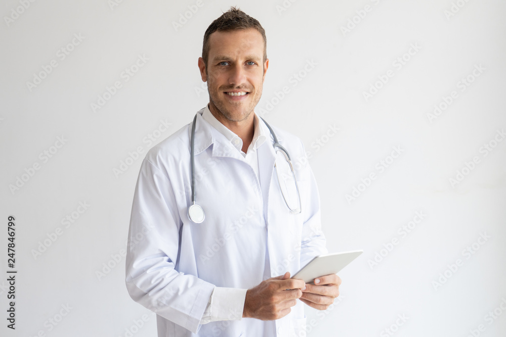 Smiling doctor with stethoscope on neck looking at camera Smiling doctor with stethoscope on neck looking at camera
